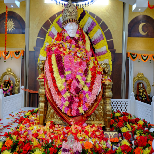 Sai Baba idol beautifully decorated with flower garlands in a temple